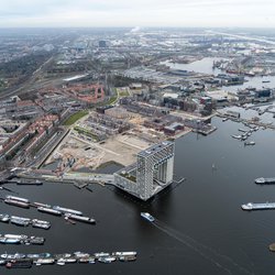 Aerial view of housing construction site in the Houthavens. Skyscraper apartment building Pontsteiger in the front with boats in the harbour. door Aerovista Luchtfotografie (bron: Shutterstock)