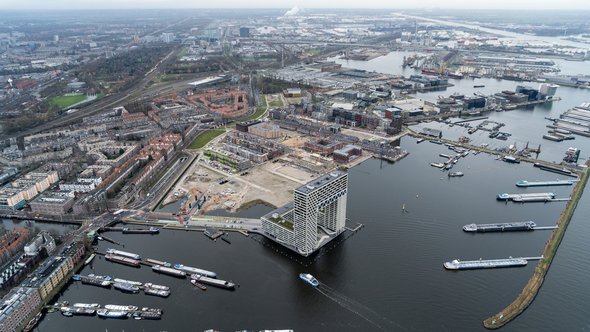 Luchtfoto van woningbouwlocatie in de Houthavens. Wolkenkrabber appartementengebouw Pontsteiger aan de voorzijde met boten in de haven. door Aerovista Luchtfotografie (bron: Shutterstock)