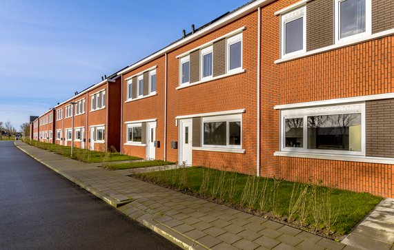 Gloednieuwe ontwikkeling van eenvoudige volkshuisvesting in een dorp in Nederland. Buurtscène van straat met moderne rijtjeshuizen in de voorsteden. door Rudmer Zwerver (bron: Shutterstock)