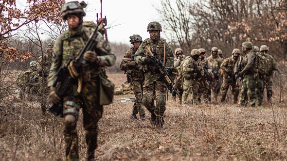 Soldaten in het veld, voorste onscherp door Ministerie van Defensie (bron: Ministerie van Defensie)