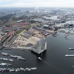 Luchtfoto van woningbouwlocatie in de Houthavens. Wolkenkrabber appartementengebouw Pontsteiger aan de voorzijde met boten in de haven. door Aerovista Luchtfotografie (bron: Shutterstock)