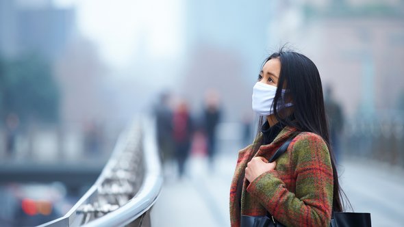 Chinese vrouw draagt masker in de stad tijdens smogdag door Bo1982 (bron: shutterstock)