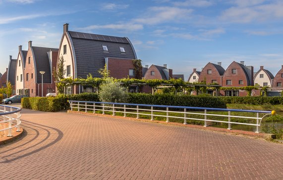 Voorstedelijk gebied met moderne familiehuizen in een kindvriendelijke buurt met bomen en tuinen door Rudmer Zwerver (bron: Shutterstock)